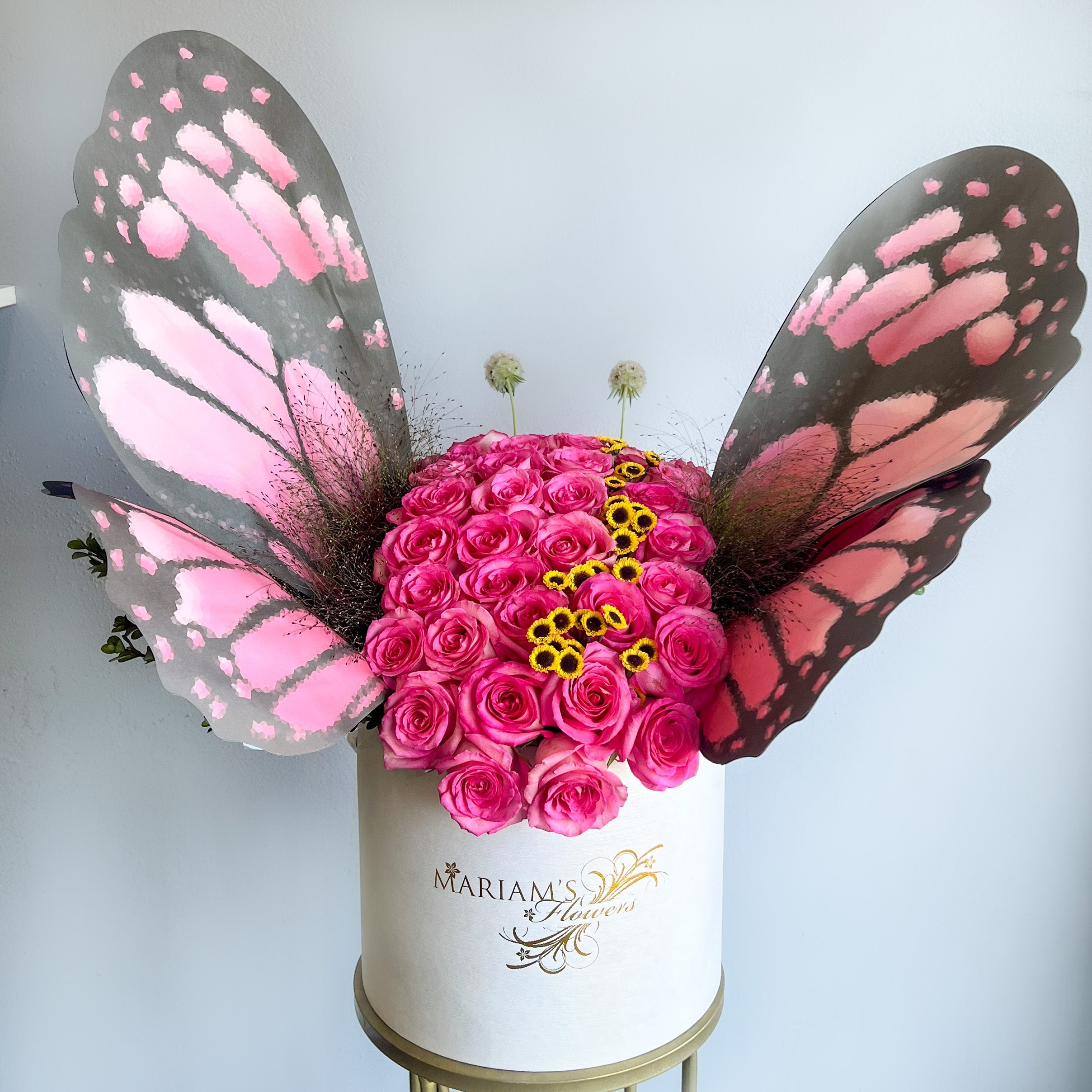 A butterfly-shaped flower arrangement in a white box, showcasing vibrant blooms and delicate petals