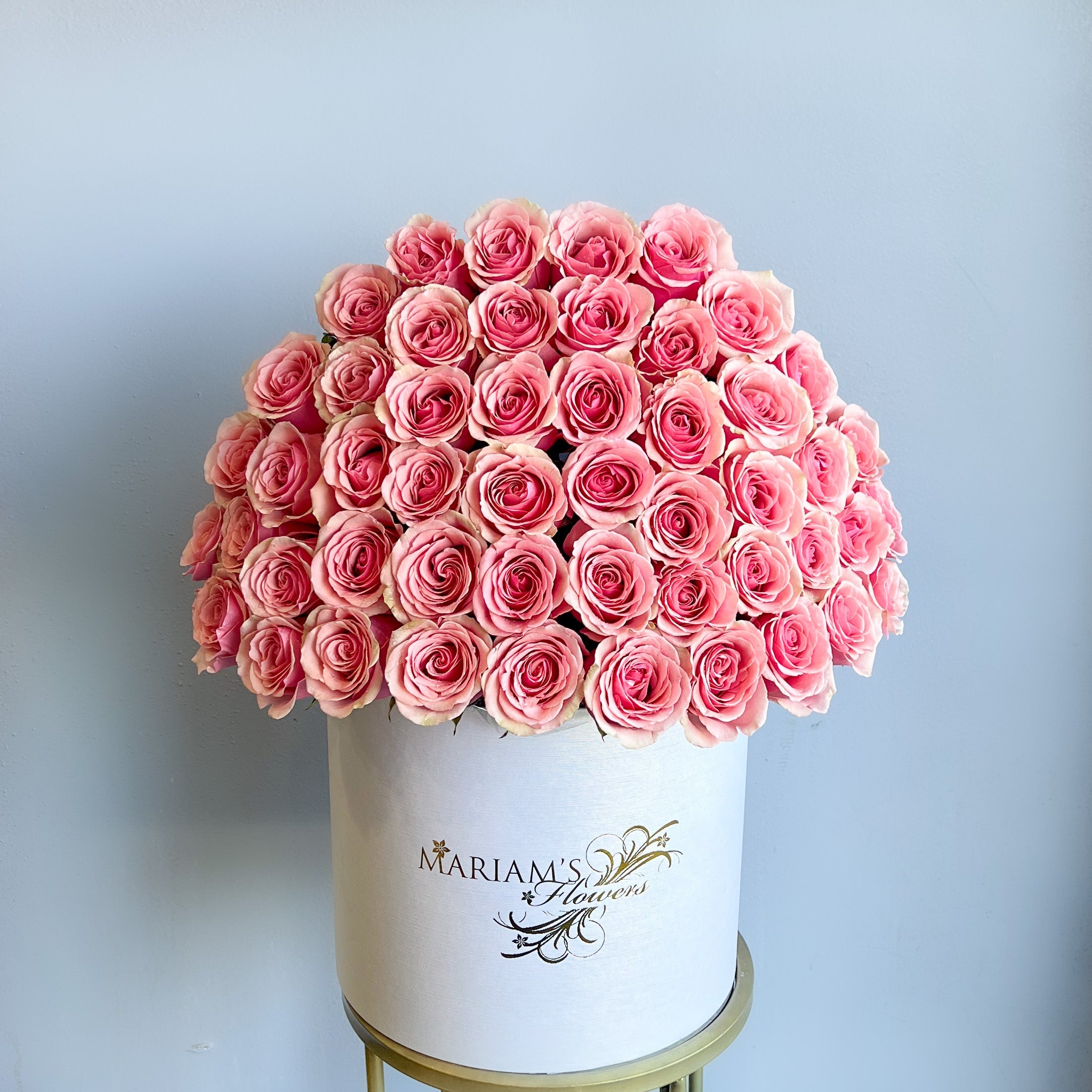 A white box filled with pink roses, designed for Mother's Day, showcasing a classic floral arrangement.