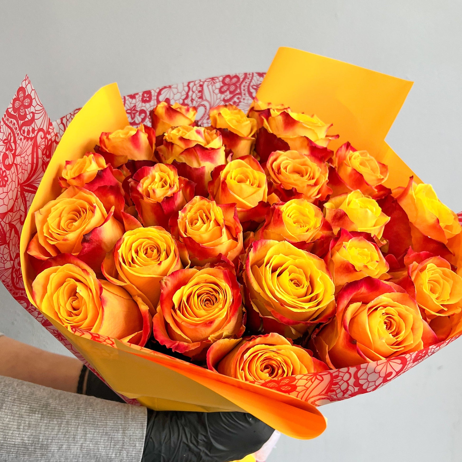 A beautifully arranged box of high yellow and orange roses, showcasing their vivid colors without any additional filler.