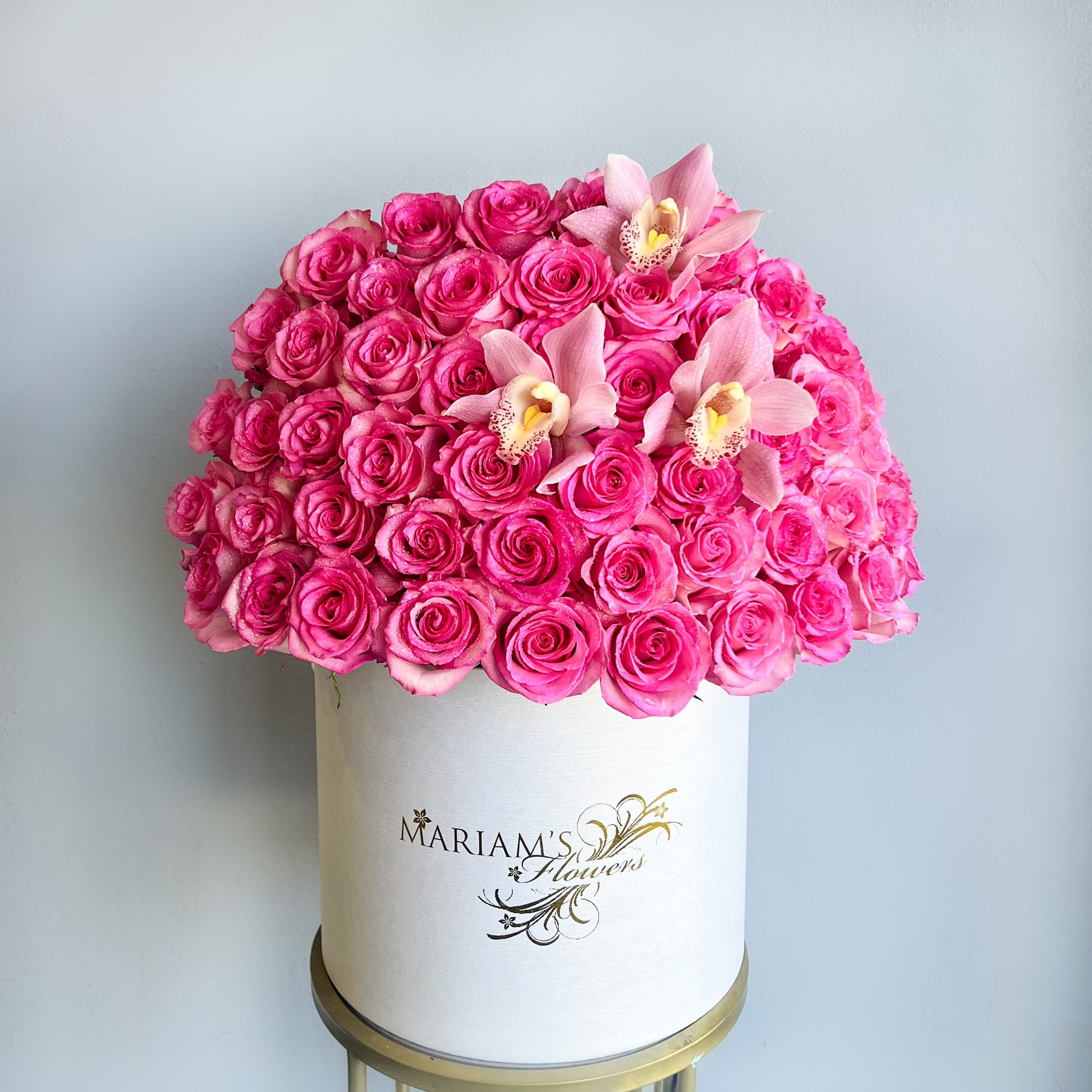 A white box filled with pink roses and butterfly orchids, designed for Mother's Day celebrations.