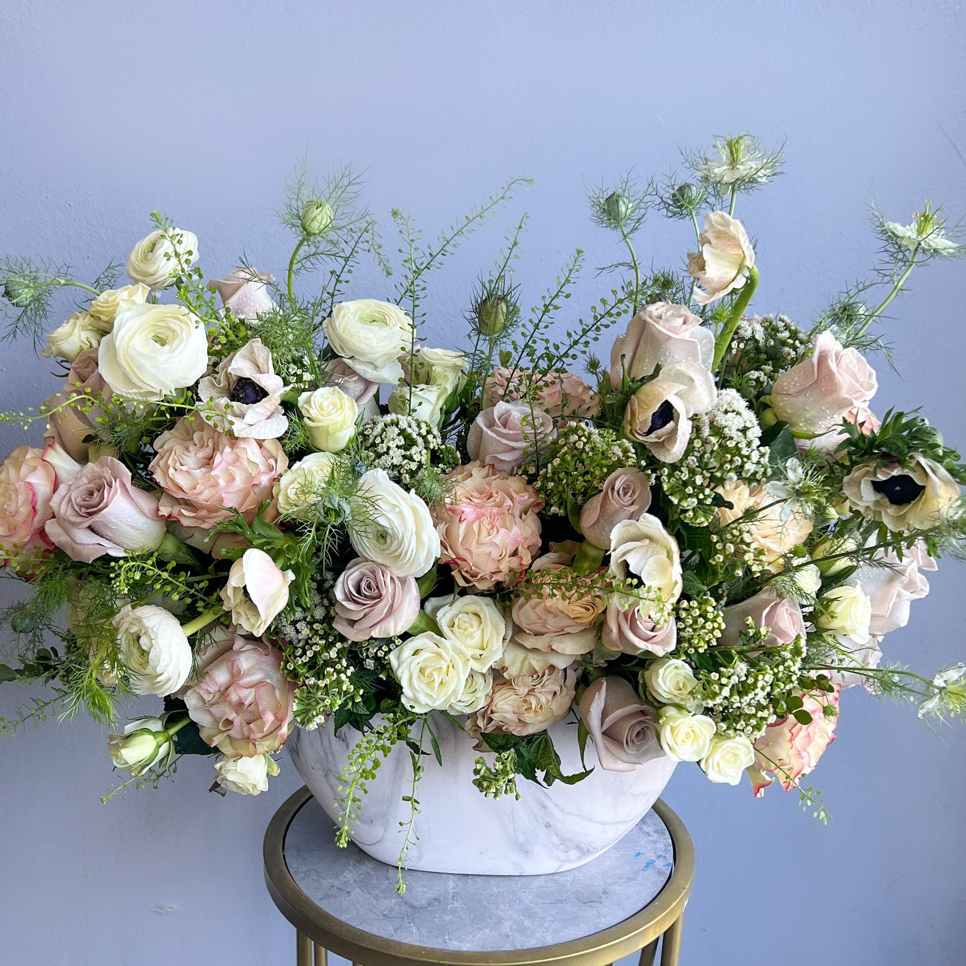 A white vase brimming with vibrant flowers is displayed on a table, enhancing the tranquil ambiance of the Secret Garden