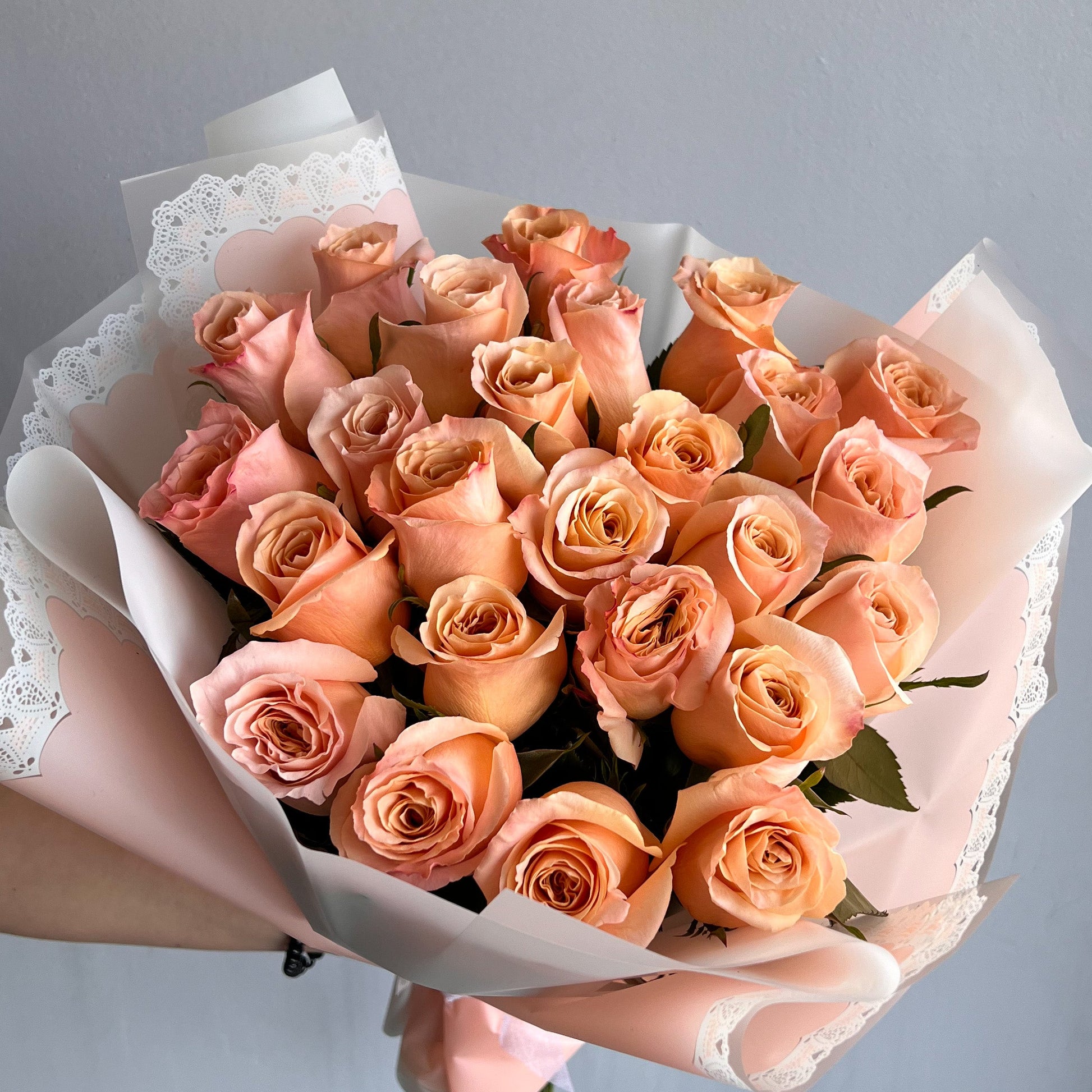 A large pink box containing a vibrant Shimmer Roses bouquet, elegantly wrapped with no filler flowers