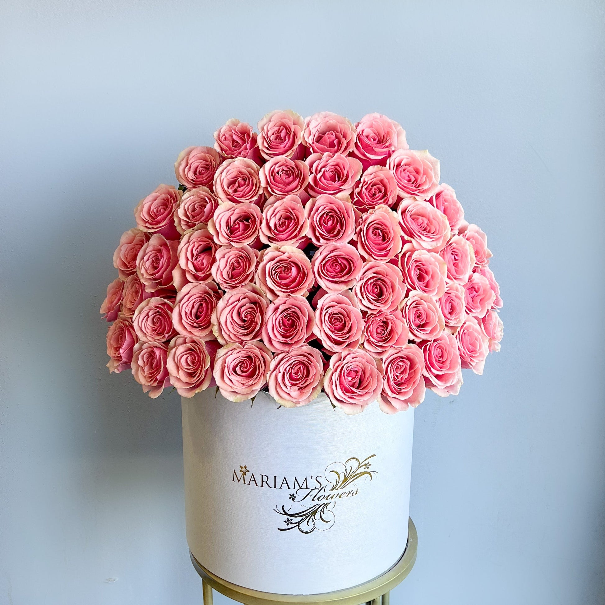 A white box filled with pink roses, designed for Mother's Day, showcasing a classic floral arrangement.