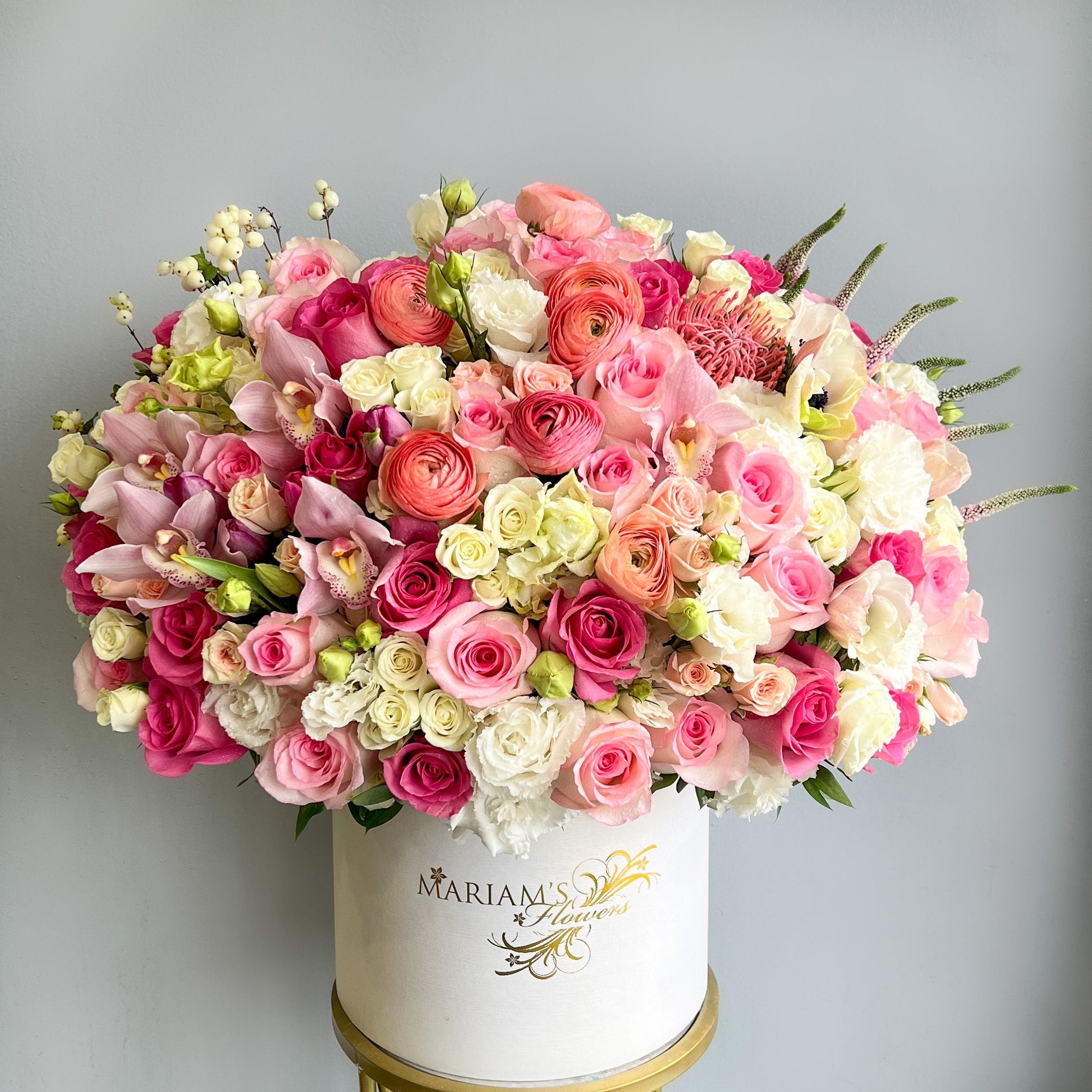 A white box containing a delightful assortment of pink and white flowers, ideal for decorative purposes