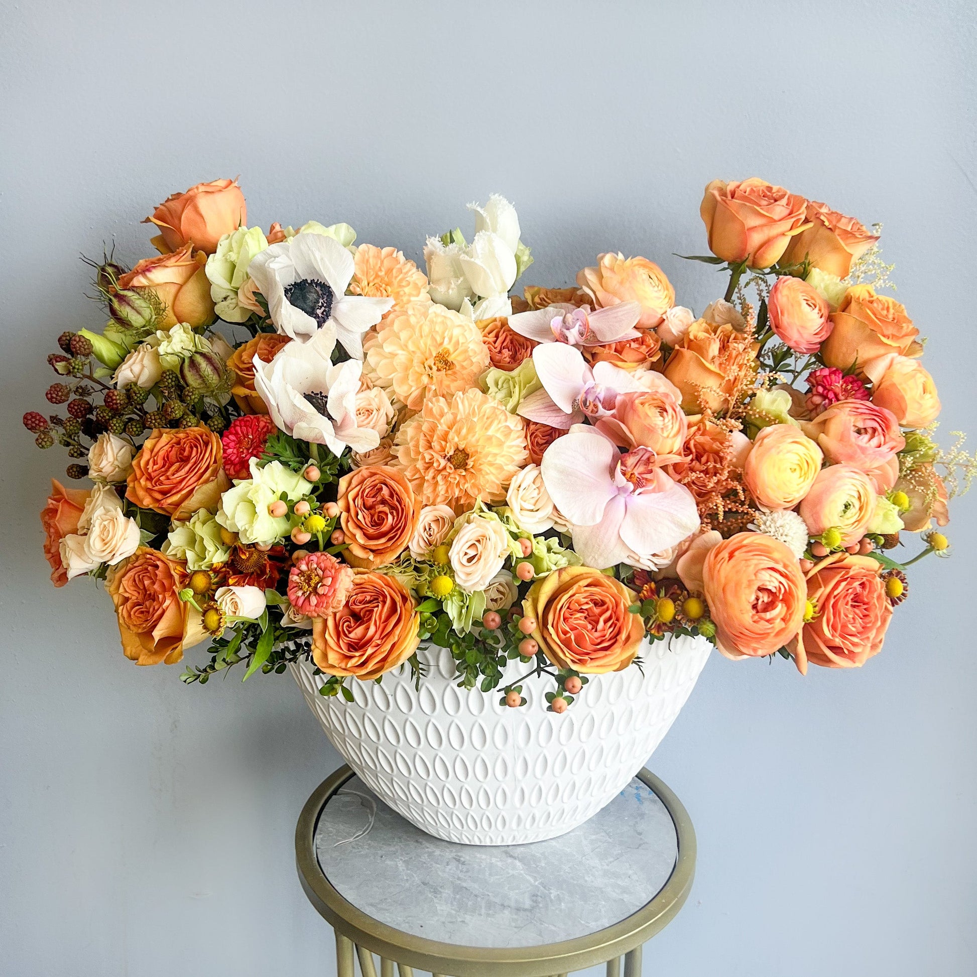 A white bowl containing a mix of orange and white flowers, capturing the essence of a tranquil sunrise.