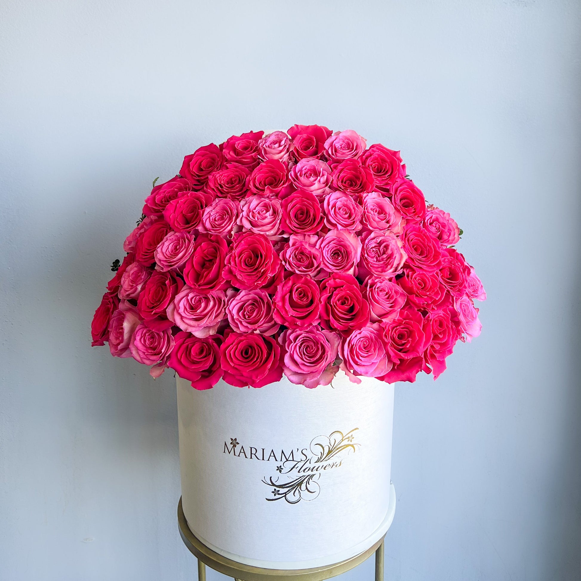 A white box filled with dark and light pink roses, designed for Mother's Day celebration.