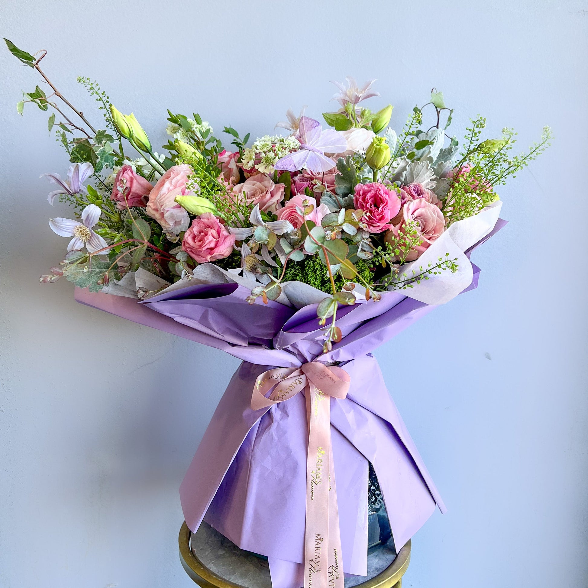 A bouquet of lavender flowers wrapped in elegant purple paper.