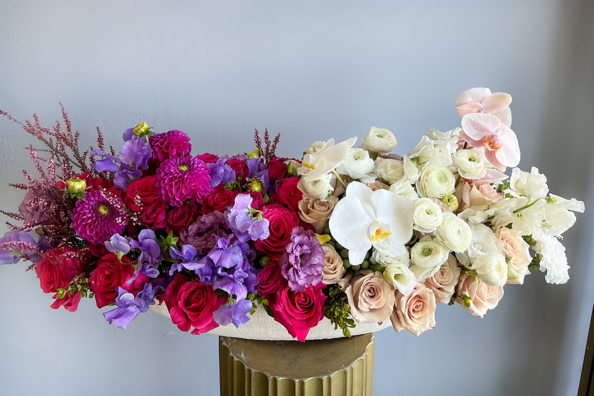 A stunning display of flowers in a vase, artistically arranged on a pedestal, highlighting the beauty of nature's colors